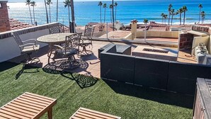 Une terrasse sur le toit avec une table ronde, des chaises et un foyer.