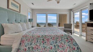 A bedroom with a large bed, a ceiling fan, a television, and a balcony with a view of the ocean. - Stunning Beach Home! 3 Oceanfront Masters w/ ensuite Baths! Panoramic Views!  (Myrtle Beach)