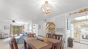 Un vaste espace de vie comprenant une table à manger, des chaises et un ventilateur de plafond.