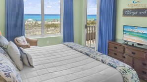 A bedroom with a large bed, a television, and a view of the beach. - Island Princess 214-Beautiful Updated 2Bd Beachfront Condo-Free Beach Service (Fort Walton Beach)