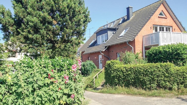 Een woonhuis met twee verdiepingen, een schuin dak, schoorsteen en een zichtbaar raam.