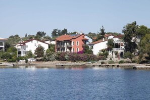 A waterfront residential area with houses featuring balconies and solar panels. - Mer Apart (Fethiye)