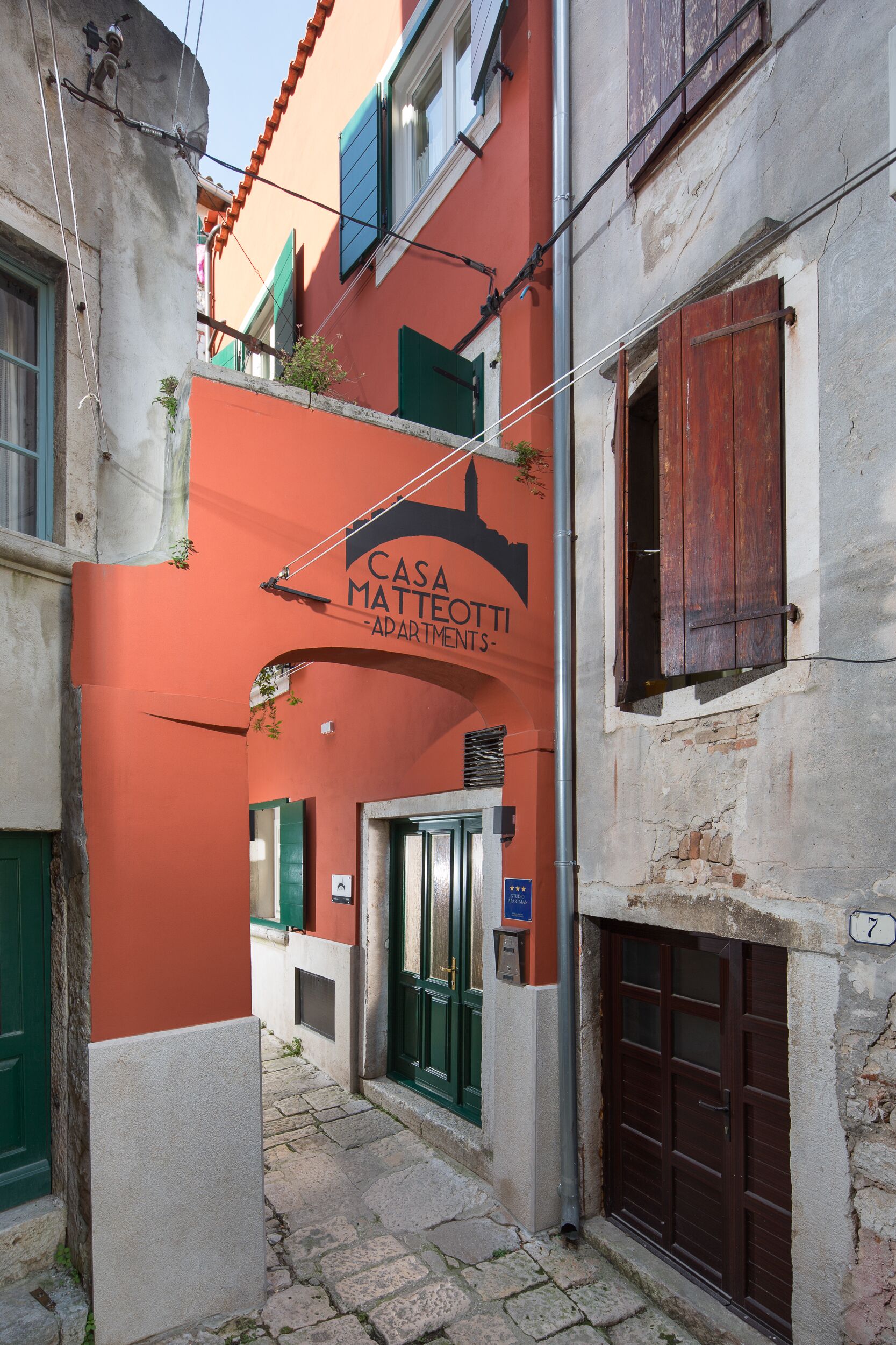 A narrow street with a building labeled "Casa Matteotti Apartments."