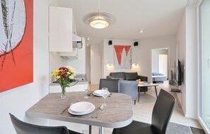 Enjoy dining in this stylish living space with a beautifully set table and comfortable seating area.