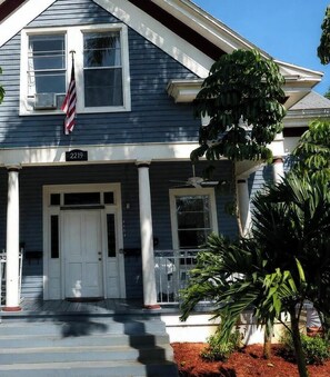 A two-story house with a front porch, white columns, and a front door.