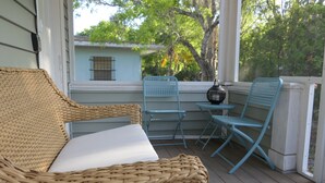 A wicker sofa and two blue chairs on a wooden deck with a view of a house and trees. - Sun, beach, and great savings: huge discounts on holiday destinations! (Fort Myers)