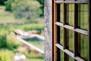 A close-up of a wooden window frame with a blurred outdoor view. - Manoir de Jouralem (Blaison-Saint-Sulpice)