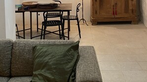 A dining area with a table, chairs, a lamp, and a cabinet.