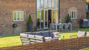A brick house with a patio, a sofa, a table, and chairs. - Thatch Barn, Burlingham , Norfolk (Buringham Green,)