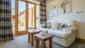 A living room with a sofa, two wooden tables, and a large window with curtains. - Thatch Barn, Burlingham , Norfolk (Buringham Green,)