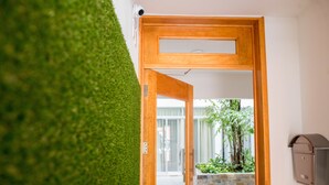 Una puerta que da a un cuarto con vistas a un jardín y un buzón.