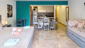 Suite estudio Deluxe | Zona de estar | Una televisión de pantalla plana, películas de pago