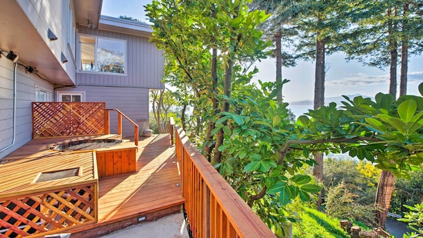 A wooden deck with a hot tub, surrounded by lush greenery and tall trees. - Walk to Keller Beach: Waterfront Studio w/ Hot Tub (Point Richmond)
