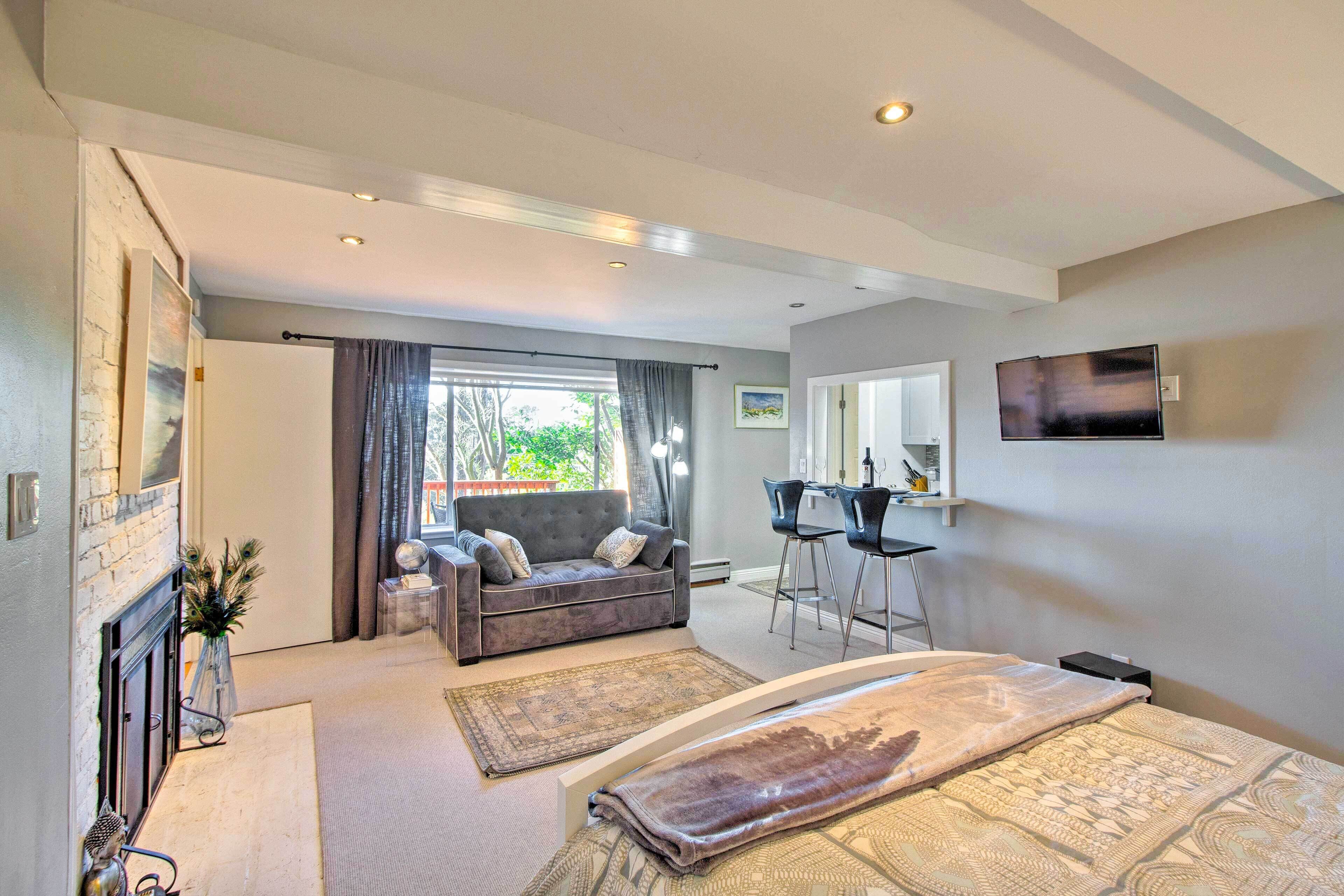 Une chambre d’hôtel moderne équipée d’un canapé, d’un coin repas, d’une télévision à écran plat et d’un grand lit.