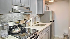 A modern kitchen with stainless steel appliances, a coffee maker, and a kettle on the stove. - Walk to Keller Beach: Waterfront Studio w/ Hot Tub (Point Richmond)