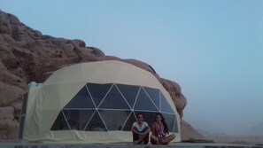 A dome-shaped tent with a geometric window design, set against a rocky desert backdrop. - Jamal rum camp (Wadi Rum)