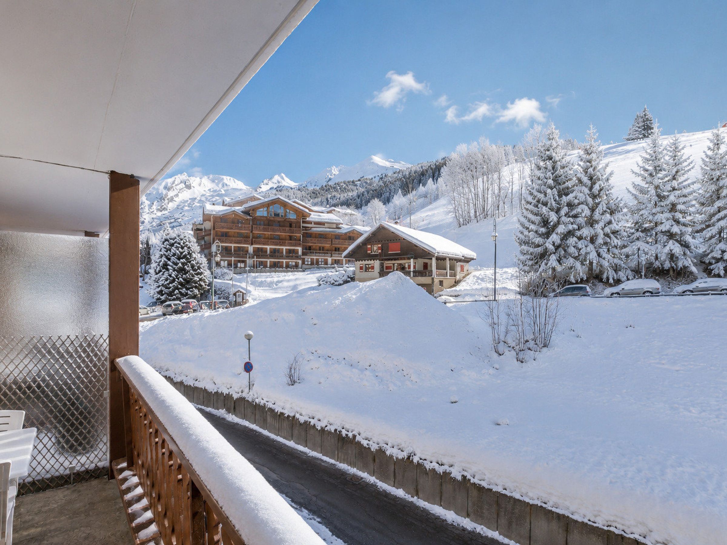 A snow-covered mountain landscape with a wooden building and a ski lift.