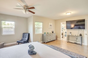 A bedroom with a bed, a ceiling fan, a dresser, a TV, and a window. - Fullerton Vacation Rental w/ Private Pool! (Fullerton)