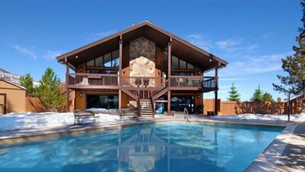 Eine zweistöckige Lodge mit Pool davor.
