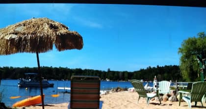 WATERFRONT COTTAGE Stocked kitchen, wifi, tiki bar,
Beach, firepit, kayaks, PET