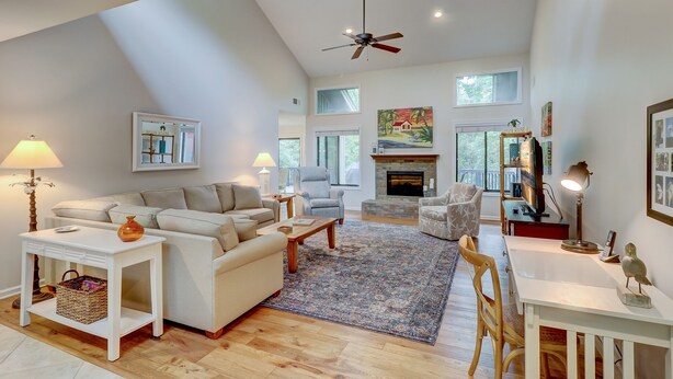A spacious living room with a high ceiling, a fireplace, and a large window. - 4 Hollyberry - Dog Friendly.  Great Community Amenities (Hilton Head Island)