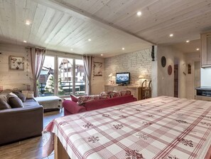 Une pièce confortable avec un grand lit, un canapé, une télévision et une table à manger.