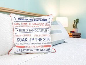 A pillow with 'BEACH RULES' text and a list of activities like building sandcastles and soaking up the sun. - Bay View Villas 101 | Water Views, Community Pool (Tybee Island)