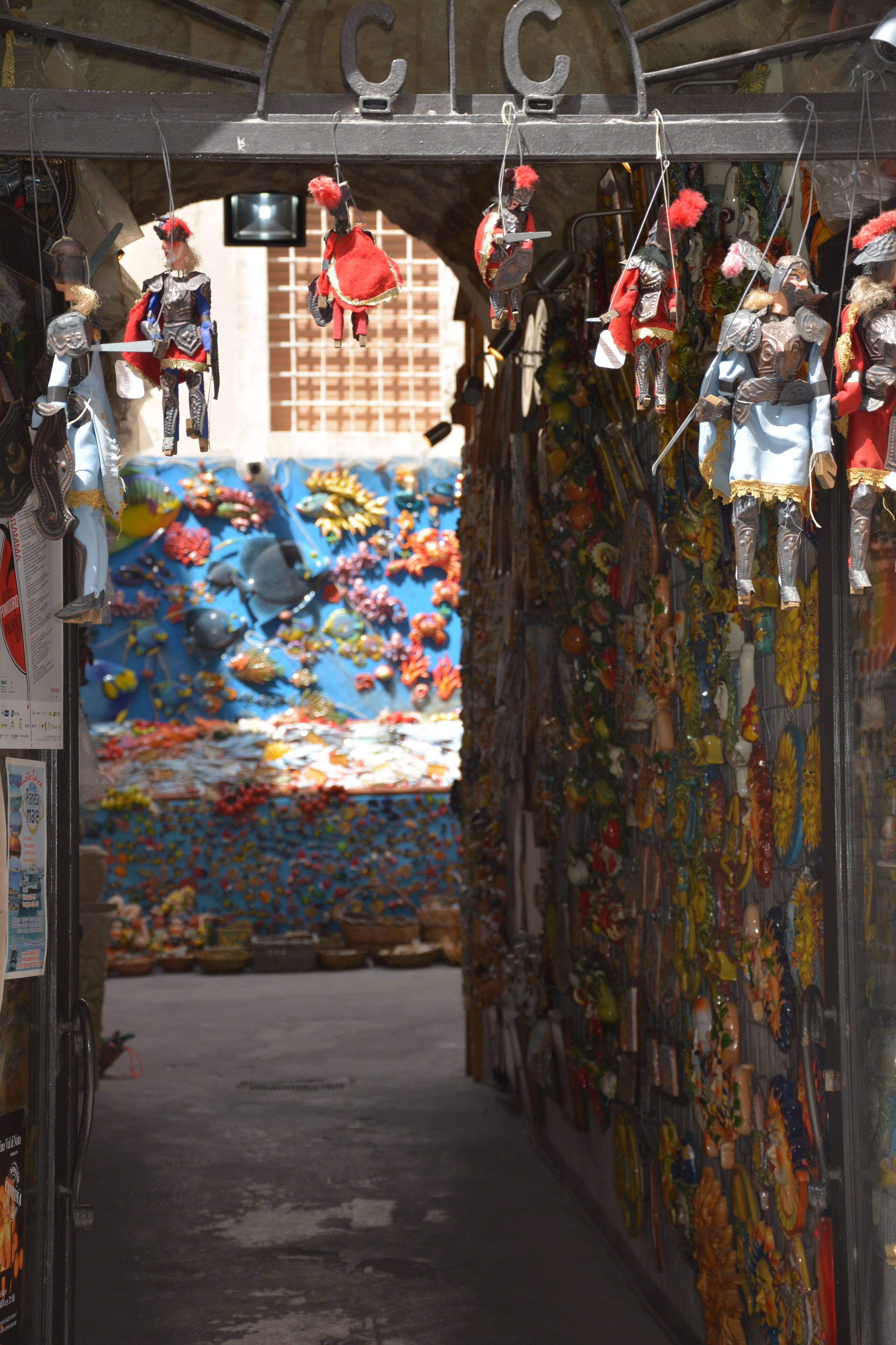Un callejón estrecho adornado con figuritas y decoraciones hechas a mano, en paredes coloridas.