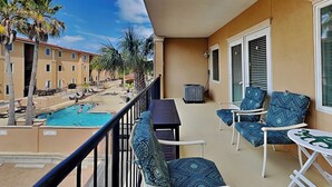 A balcony with a pool, chairs, and a table. - Private Balcony, Community Pool, 30 Yards to Beach (Tybee Island)