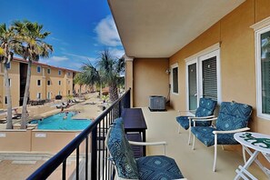 Ein Balkon mit Pool, Stühlen und einem Tisch.