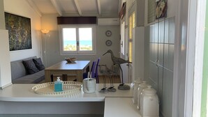 Una cocina acogedora con comedor, vista al océano y techo con vigas a la vista.