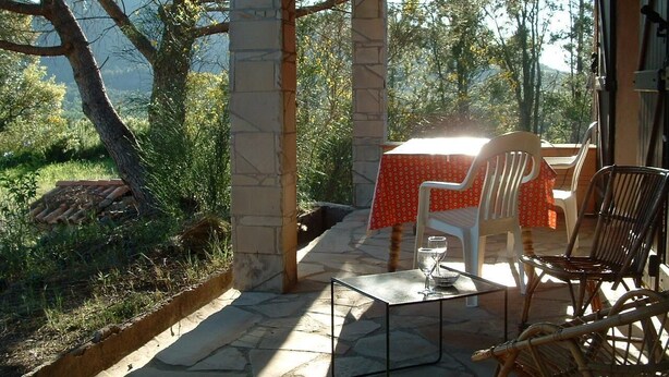 An outdoor patio with stone flooring, a table with a red tablecloth, and wicker chairs. - Villa for 8 people, private pool villa with unobstructed views, Bagnols-en-F, beautiful location (Bagnols-En-Forêt)