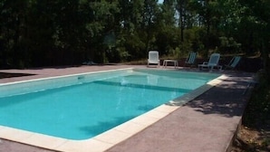 A rectangular swimming pool with a tiled edge, surrounded by a concrete deck. There are four lounge chairs aligned along the pool's edge. - Villa for 8 people, private pool villa with unobstructed views, Bagnols-en-F, beautiful location (Bagnols-En-Forêt)