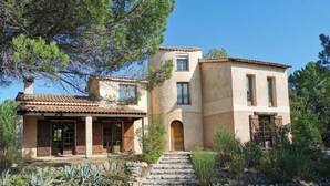 A two-story house with a tiled roof, stone steps leading to the entrance, and a garden with various plants. - Villa for 8 people, private pool villa with unobstructed views, Bagnols-en-F, beautiful location (Bagnols-En-Forêt)