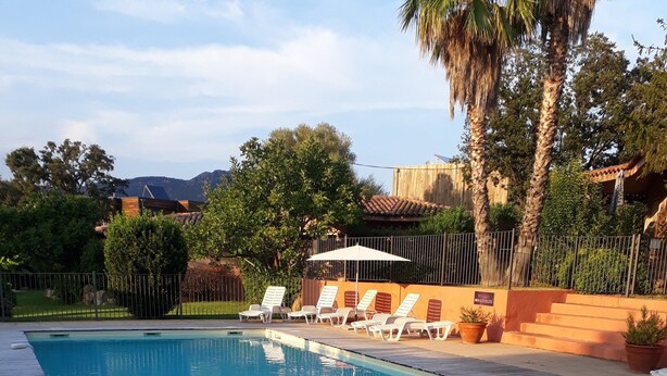 A rectangular swimming pool with a wooden deck in the foreground.