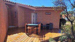 A wooden deck with a table and chairs, a door, and a sign reading "PAGLIA ORBA".