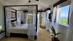 Una camera da letto con un letto a baldacchino, una TV e vista sul paesaggio.