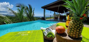 Ein Poolbereich mit Meerblick, einer Hängematte und einer Ananas.
