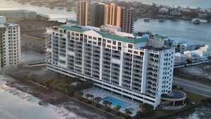 Un hôtel de grande hauteur doté de nombreux balcons, d’une piscine et offrant une vue sur l’eau et les bâtiments environnants.
