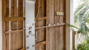 A wooden wall with built-in electrical outlets and switches, a shelf with decorative items, and a small sign. - Beach Digs | Bay View, Heated Pool, Steps to Beach (Tybee Island)
