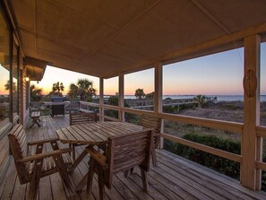 Enjoy the serene ocean views from this beachside deck, featuring comfortable benches and picnic tables.