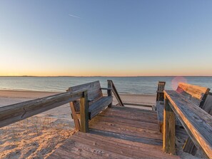 Walk along the beach on a wooden boardwalk with access to the ocean.