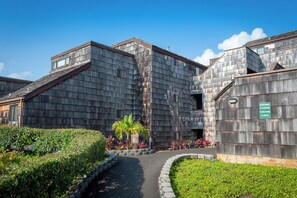 A building with a wooden exterior and a pathway leading to the entrance.