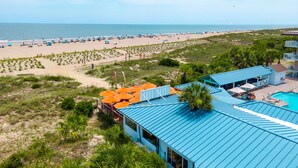 A beach resort with a swimming pool, beach umbrellas, and a view of the ocean. - Tybee Beach Club 137 | Condo Overlooking Beach! (Tybee Island)