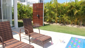 Un espace patio avec des chaises en osier, une table de billard et un mur en bois.