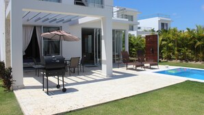Une maison moderne à deux étages, dotée d’un patio, d’une piscine et d’un espace barbecue.