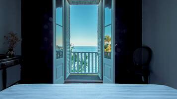 Une porte ouverte donnant sur un balcon avec vue sur l’océan.
