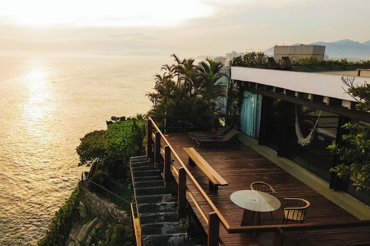 A wooden deck with a table and chairs overlooking a body of water.