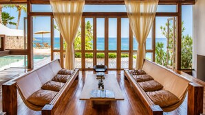 A room with a wooden floor, two leather sofas, a central table, and large windows with curtains. -  CLIFFSIDE - Boutique Hotel & Spa (Rio de Janeiro)