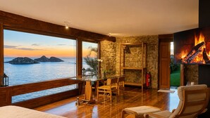 A room with a large window overlooking the sea, a fireplace, and a bed. -  CLIFFSIDE - Boutique Hotel & Spa (Rio de Janeiro)